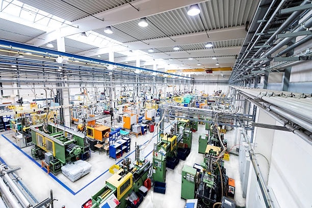 Wide view of a bright, modern factory floor filled with automated industrial machinery and production lines
