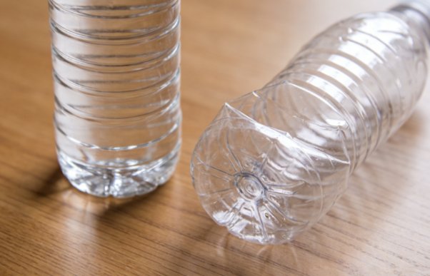 Two plastic water bottles, one intact and the other crushed.